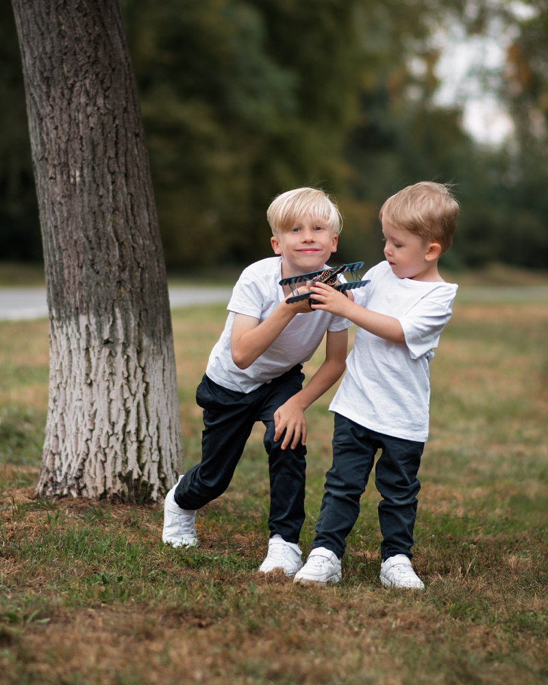 Familienfotografie im Park – Zwei blonde Jungs mit ihren Eltern bei grauem Spätsommerwetter in Berlin