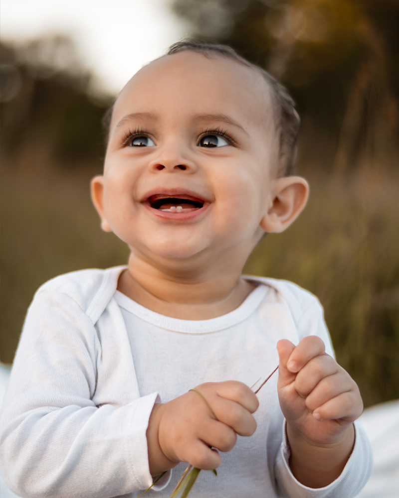Familienfotografie im Feld – Babyjunge mit Eltern bei Sonnenuntergang und Golden Hour im Sommer in Berlin