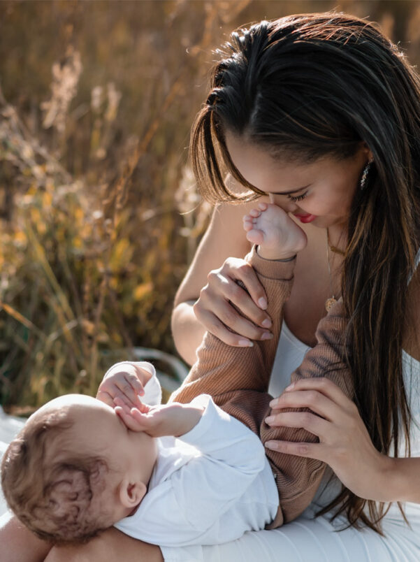 Familienfotografie im Feld – Babyjunge mit Eltern bei Sonnenuntergang und Golden Hour im Sommer in Berlin