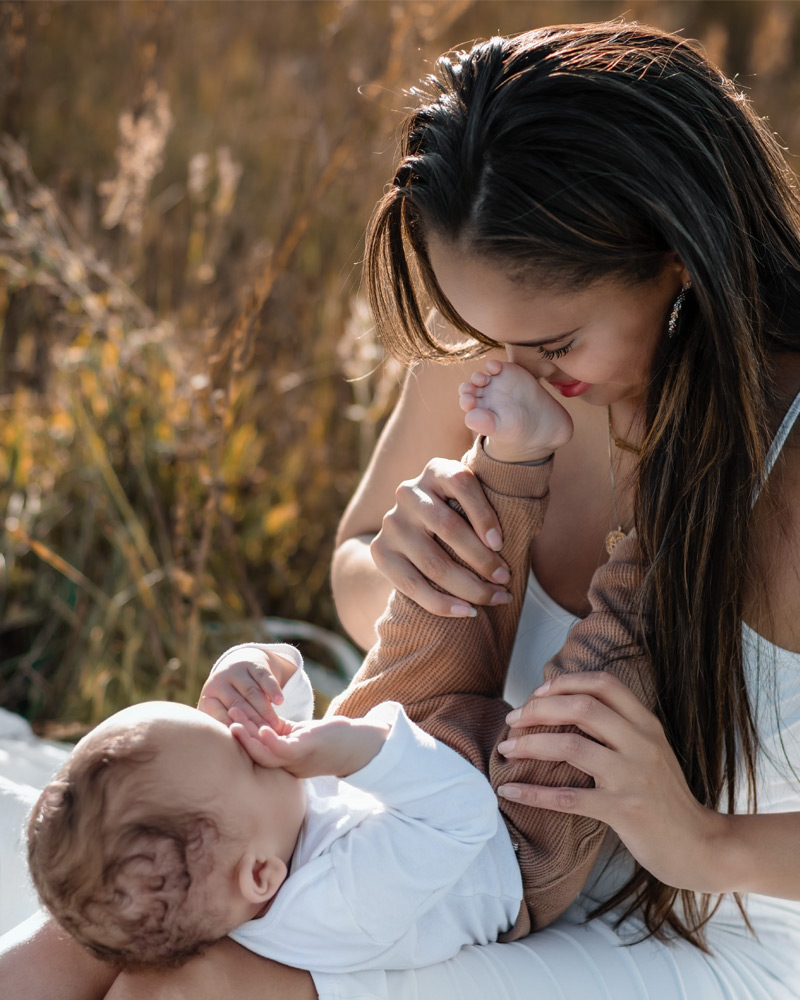 Familienfotografie im Feld – Babyjunge mit Eltern bei Sonnenuntergang und Golden Hour im Sommer in Berlin