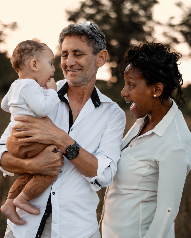 Familienfotografie im Feld – Babyjunge mit Eltern bei Sonnenuntergang und Golden Hour im Sommer in Berlin
