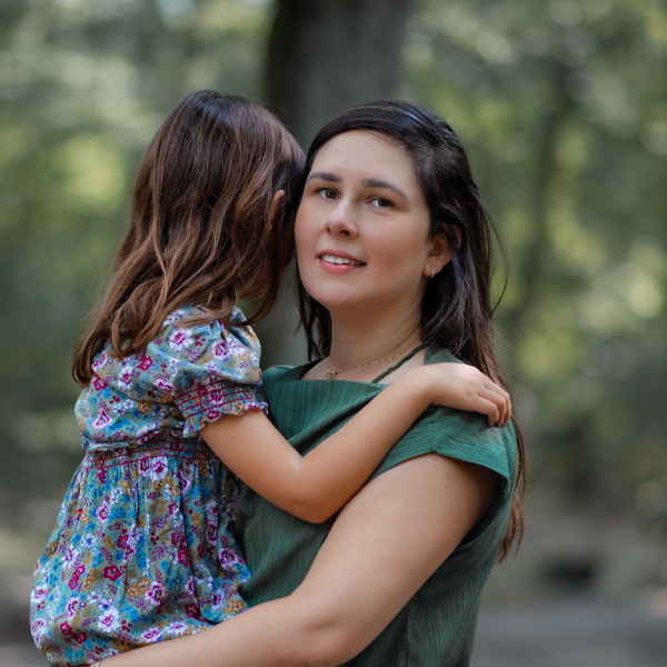 Mama trägt kleines Mädchen im Sommerwald – Familienmoment in Berlin