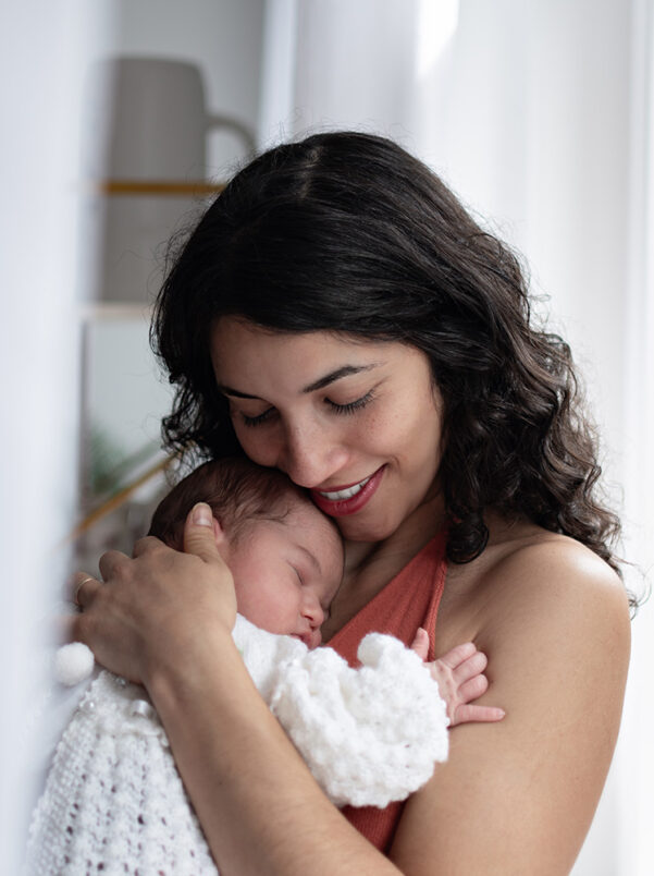 Mama hält ihr Neugeborenes liebevoll im Arm