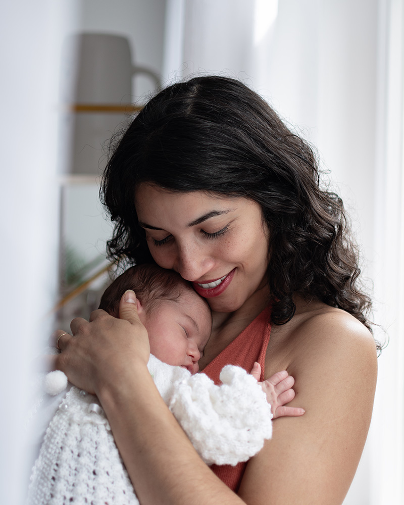 Mama hält ihr Neugeborenes liebevoll im Arm
