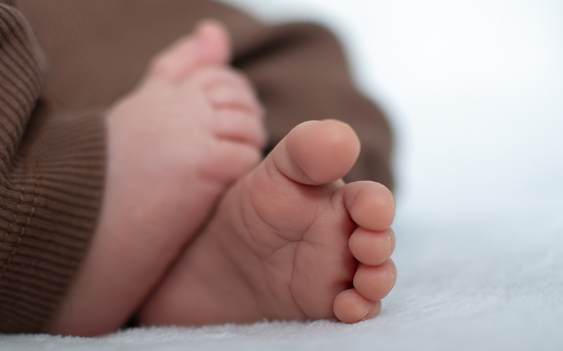 Nahaufnahme der winzigen Babyfüße auf einer weichen Decke